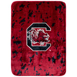 A plush red throw blanket with the South Carolina Gamecocks logo in the center.